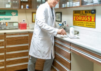 Dr. Rowan Counting Pills in his Pharmacy