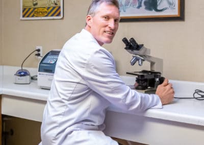 Dr. Rowan with Microscope in Laboratory