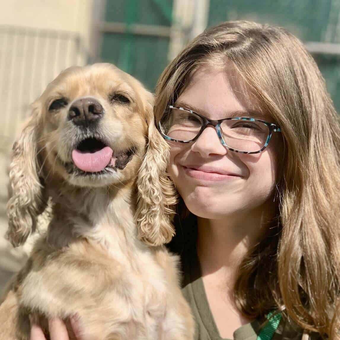 Amy, kennel Assistant, gets some love from a boarding dog Katie Kennel Assistant